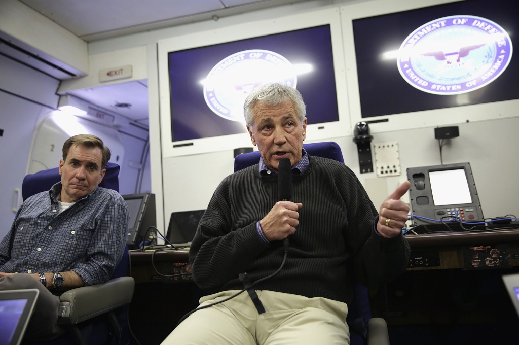 Admiral John Kirby (kiri) bersama Menhan AS Chuck Hagel di sebuah pesawat -- ALEX WONG / GETTY IMAGES NORTH AMERICA / AFP