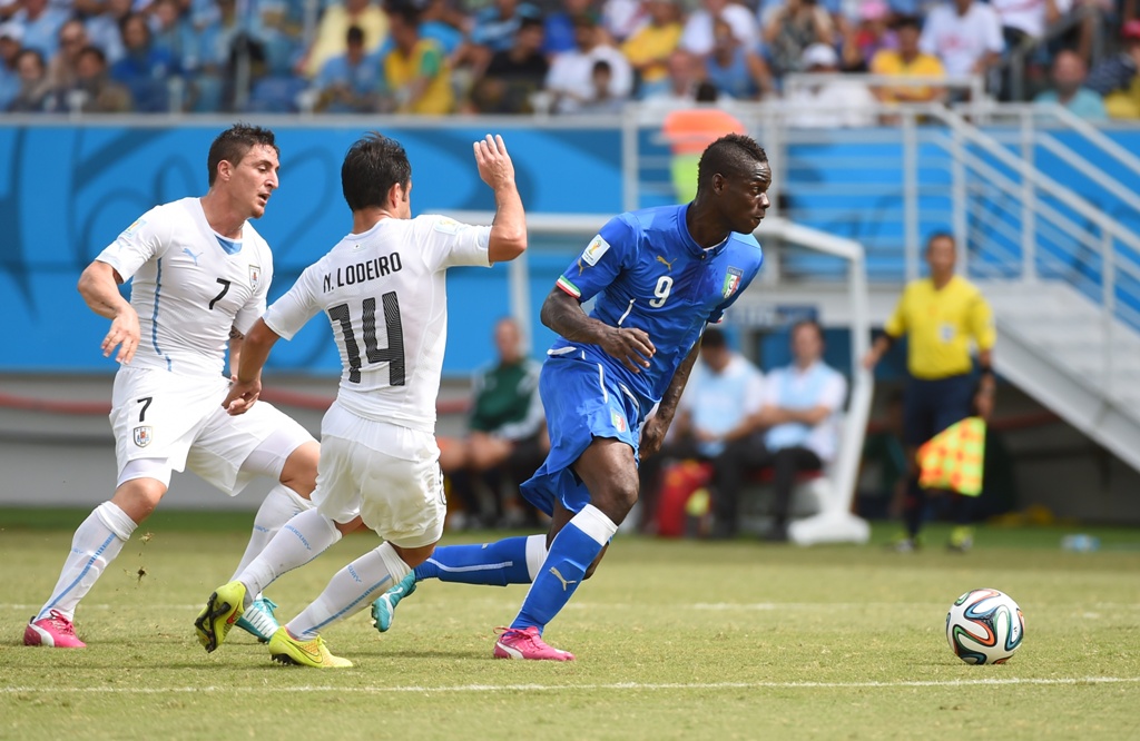 Balotelli melepaskan diri dari kawalan pemain Uruguay.(foto:AFP/Emmanuel Dunand)