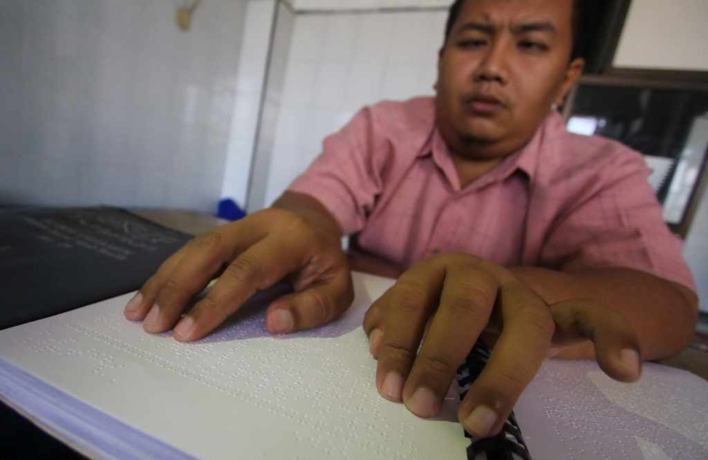 Taufik Windu Asmoro membaca Alquran huruf Braille./MI/Widjajadi.