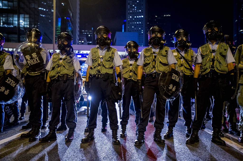 Polisi anti huru-hara bersiaga menghadapi ratusan pengunjuk rasa di kompleks pemerintahan Hong Kong - AFP/Xaume Olleros