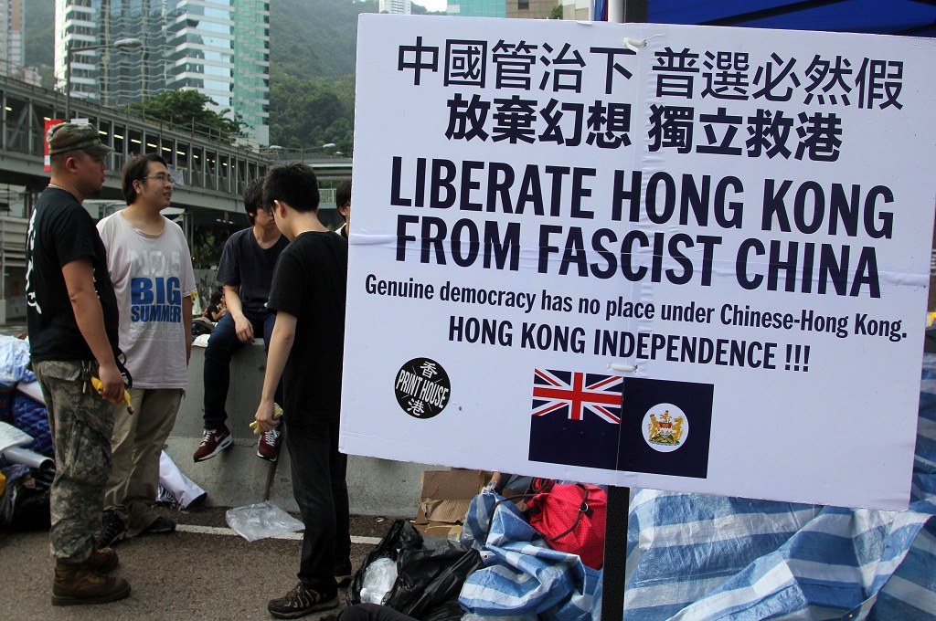 Pendemo di Hong Kong membawa banner bertuliskan kecaman terhadap pemerintahan pusat Tiongkok di Beijing - AFP/LAURENT FIEVET