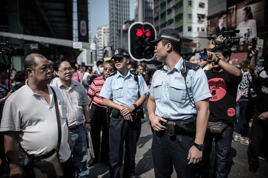 Polisi bersiaga di dekat barikade yang dipasang pendemo pro demokrasi di Hong Kong - AFP/PHILIPPE LOPEZ