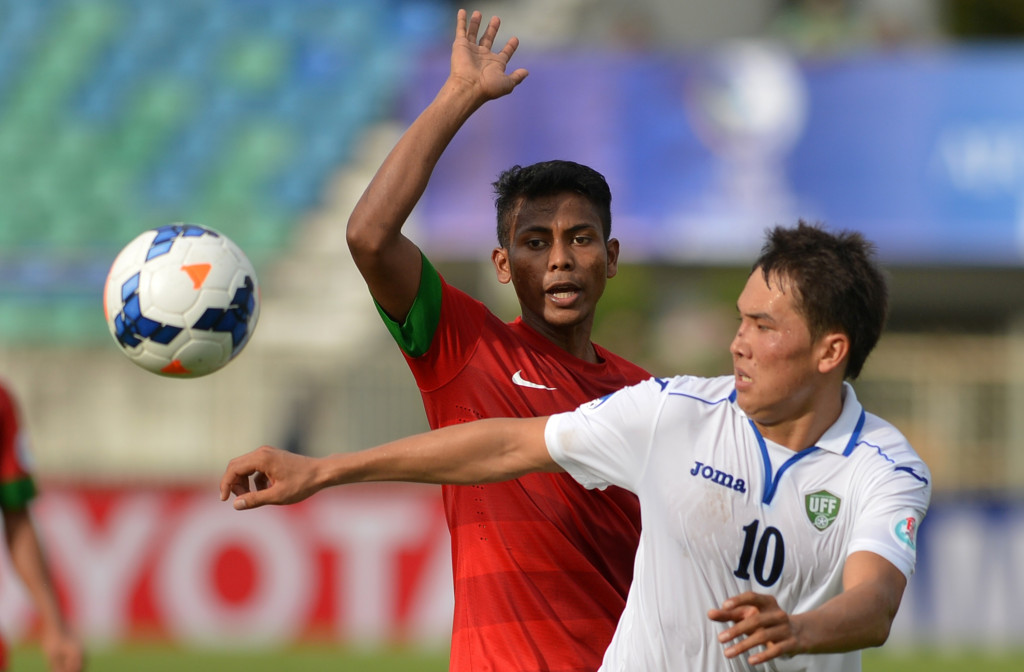 INDONESIA DIKALAHKAN UZBEKISTAN: Pesepakbola timnas U-19 Indonesia Zulfiandi (kiri) berebut bola dengan pesepakbola timnas U-19 Uzbekistan Shukurov Otabek (kanan) saat pertandingan Grup B turnamen Piala Asia U-19 di Stadion Thuwunna Youth Training Center 