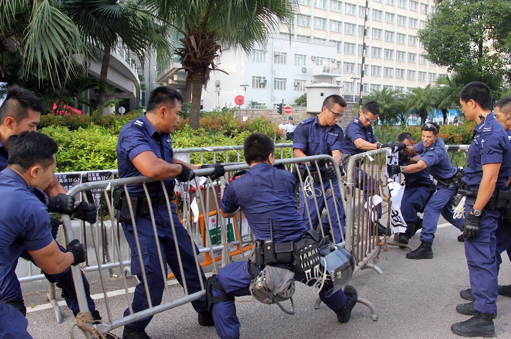 Polisi Hong Kong menyingkirkan sejumlah barikade besi di dekat kompleks gedung pemerintahan - AFP/LAURENT FIEVET