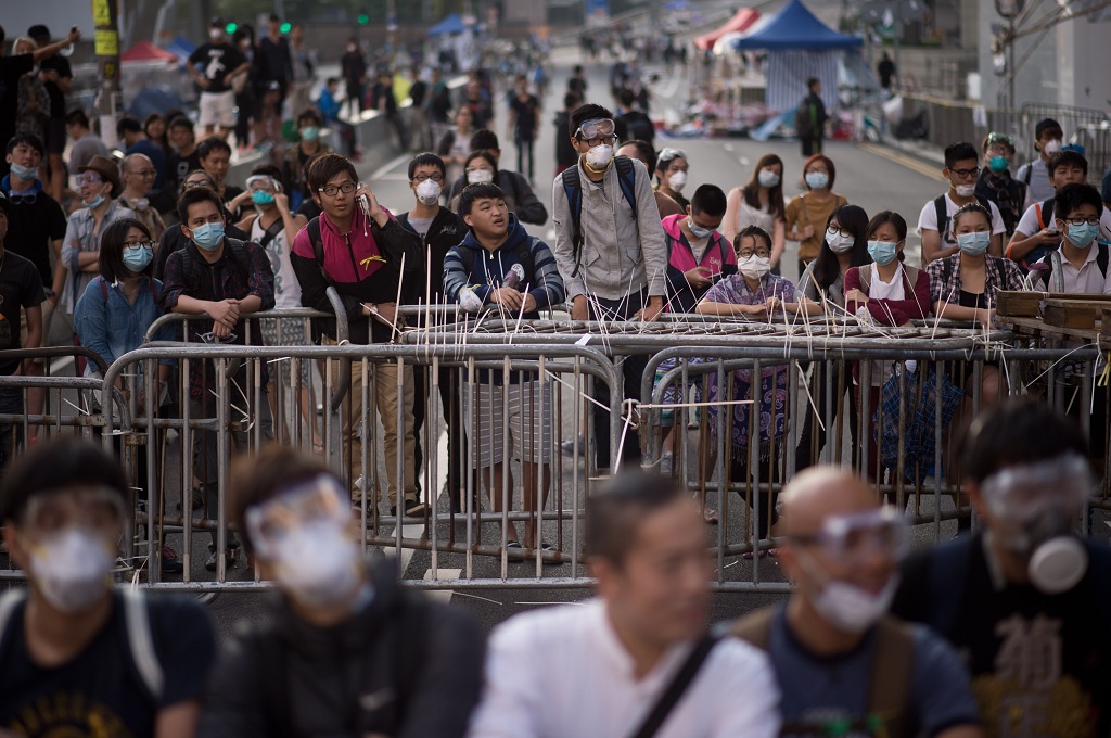 Demonstran pro demokrasi Hong Kong berkumpul di sekitar barikade besi yang mereka pasang sejak dua pekan lalu - AFP/ED Jones