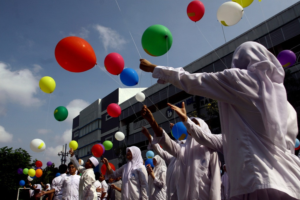 Siswa Sekolah Al Azhar melepas balon yang ditempeli kertas bertuliskan cita-cita dan pesan bagi calon pemimpin bangsa di halaman sekolah Al Azhar, Surabaya, Jawa Timur, Senin (7/7/2014). ANT/Suryanto