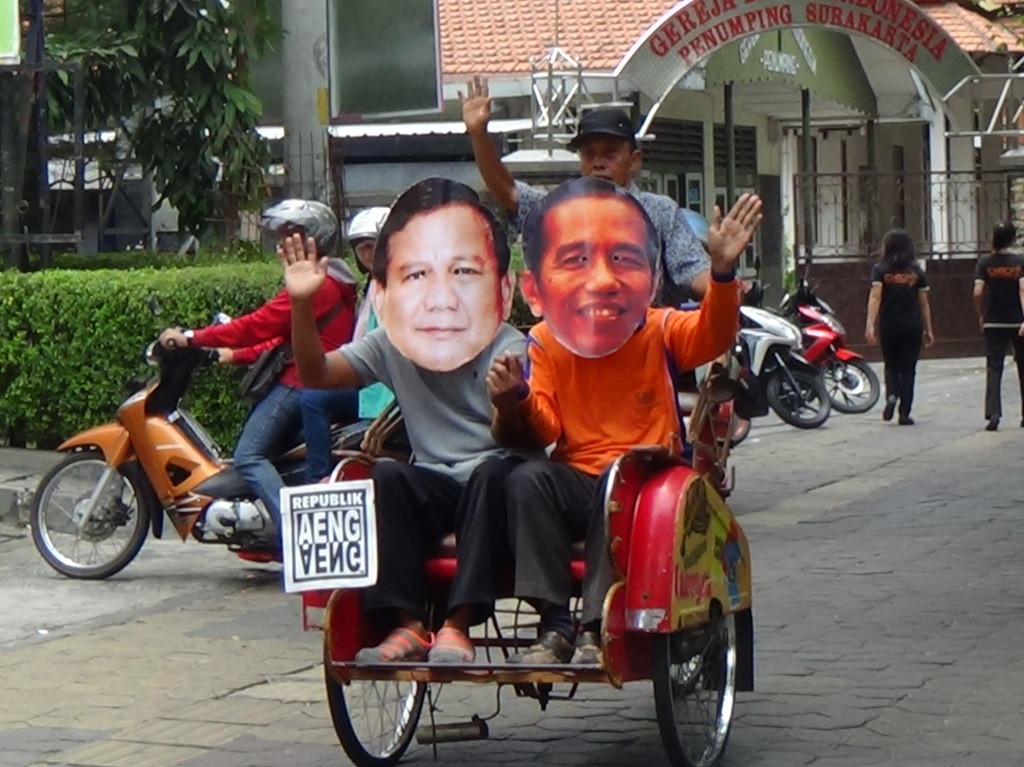 Dua warga berperan Joko Widodo dan Pabowo Subianto yang akrab naik becak di City Walk, Jalan Slamet Riyadi, Kota Solo, Jawa Tengah, Kamis (16/10/2014). MTVN/Eka Hari Wibawa