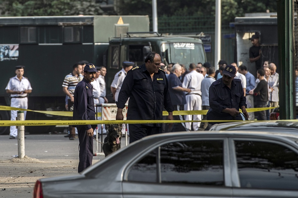 Polisi dan anjing pelacak memeriksa lokasi ledakan bom di depan Universitas Kairo, Mesir - AFP/KHALED DESOUKI