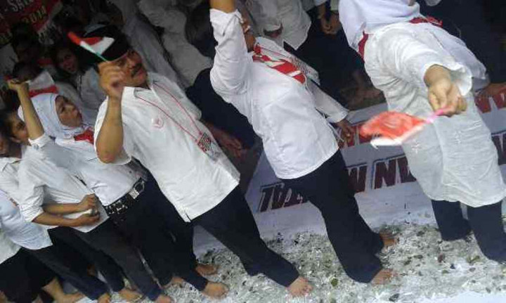 Relawan Jokowi Gelar Aksi Berjalan di Atas Pecahan Beling