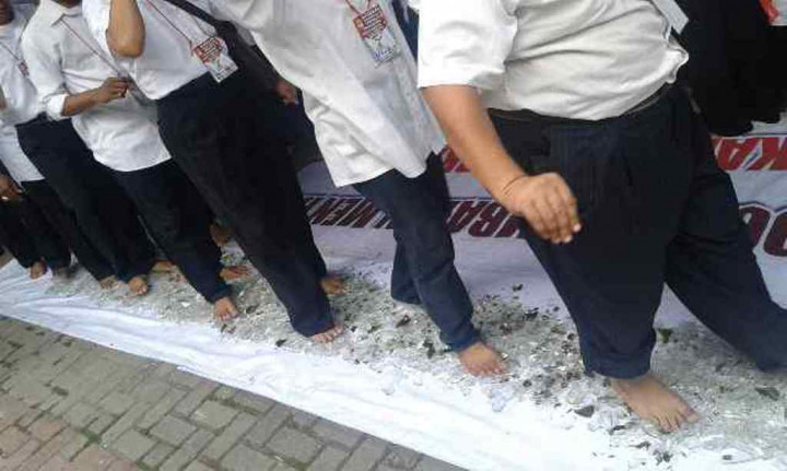 Maksud di Balik Aksi Relawan Jokowi Berjalan di Atas Beling