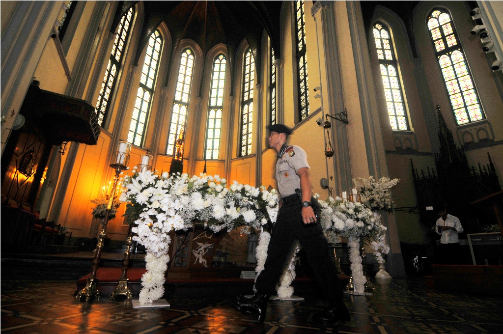 Polisi dari satuan Gegana melakukan sterilisasi sebelum misa Kamis Putih di Gereja Katedral, Jakarta, Kamis (17/4/2014).