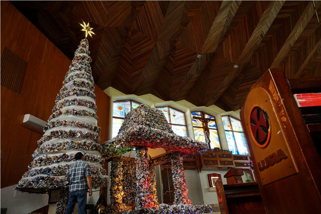 Seorang jemaat menyelesaikan pengerjaan pohon Natal yang terbuat dari kertas bekas, di Gereja Katedral Purwokerto, Banyumas, Jateng, Selasa (23/12/2014). ANT/Idhad Zakaria