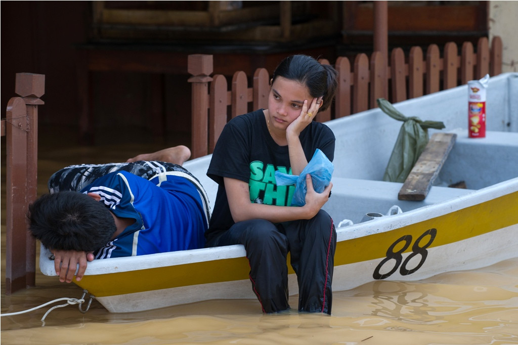 Warga yang menunggu bantuan saat banjir menghantam (Foto: AFP)