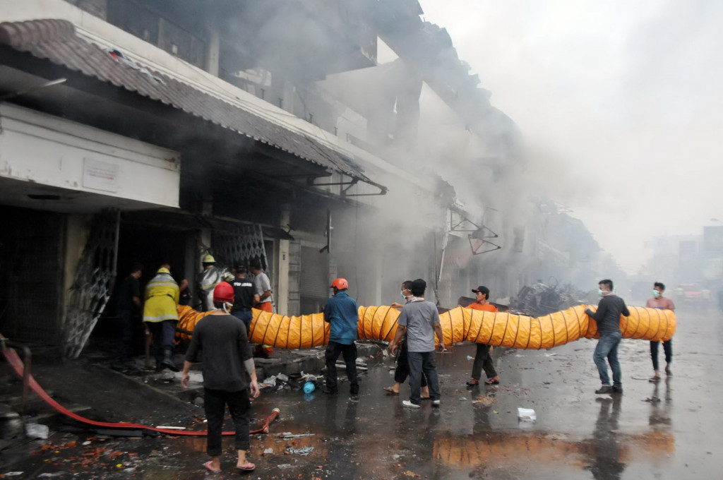 Para petugas PMK dibantu para relawan mengeluarkan asap pekat di reruntuhan Pasar Klewer/MI/Widjajadi