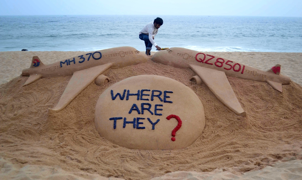 Seniman membuat patung AirAsia dan Malaysia Airlines (Foto: AFP)