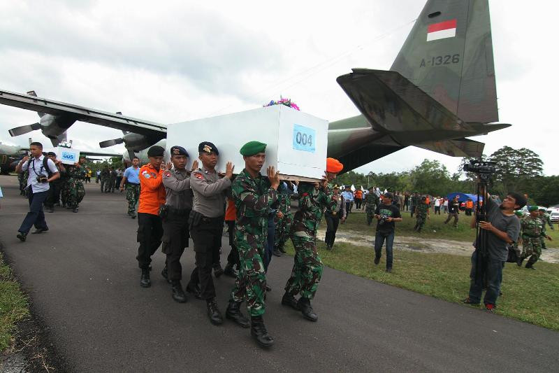 Petugas gabungan Basarnas, TNI dan Polri membawa peti berisi jenazah korban AirAsia QZ8501 ke pesawat Hercules C-130 di Lanud Iskandar, Pangkalan Bun, Kalimantan Tengah, Kamis (1/01). MI/Arya Manggala