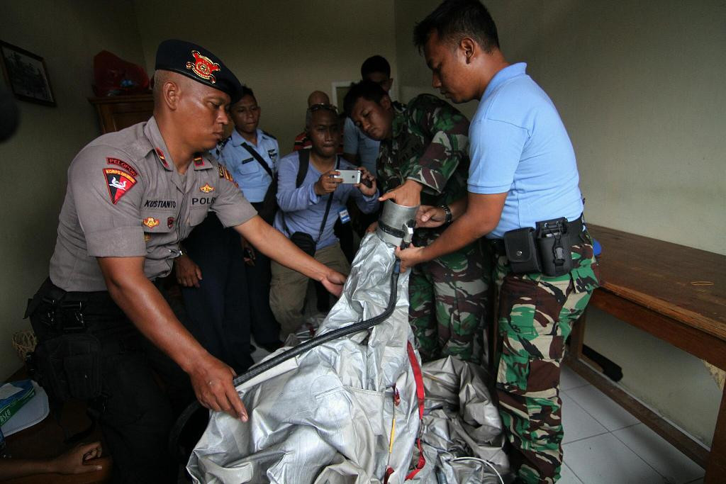  Petugas menunjukkan serpihan pesawat yang diduga bagian dari alat seluncur darurat, tangga dan pintu darurat milik pesawat AirAsia QZ 8501, Kamis (1/1/2015)--MI/Arya Manggala