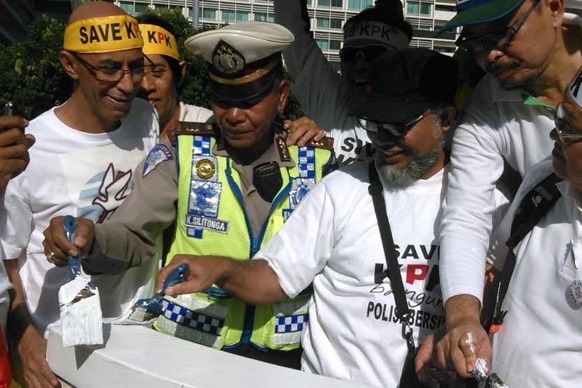 Polisi Lalulintas bersama Bambang Widjojanto (topi hitam) bersama-sama mengecat pos polisi Bundaran HI. (Foto: Metrotvnews.com/Deny Irwanto)
