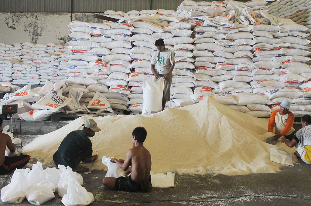 Sejumlah pekerja menimbang raskin untuk dikemas ke dalam plastik dengan berat 5 kg. (Antara/Suryanto)