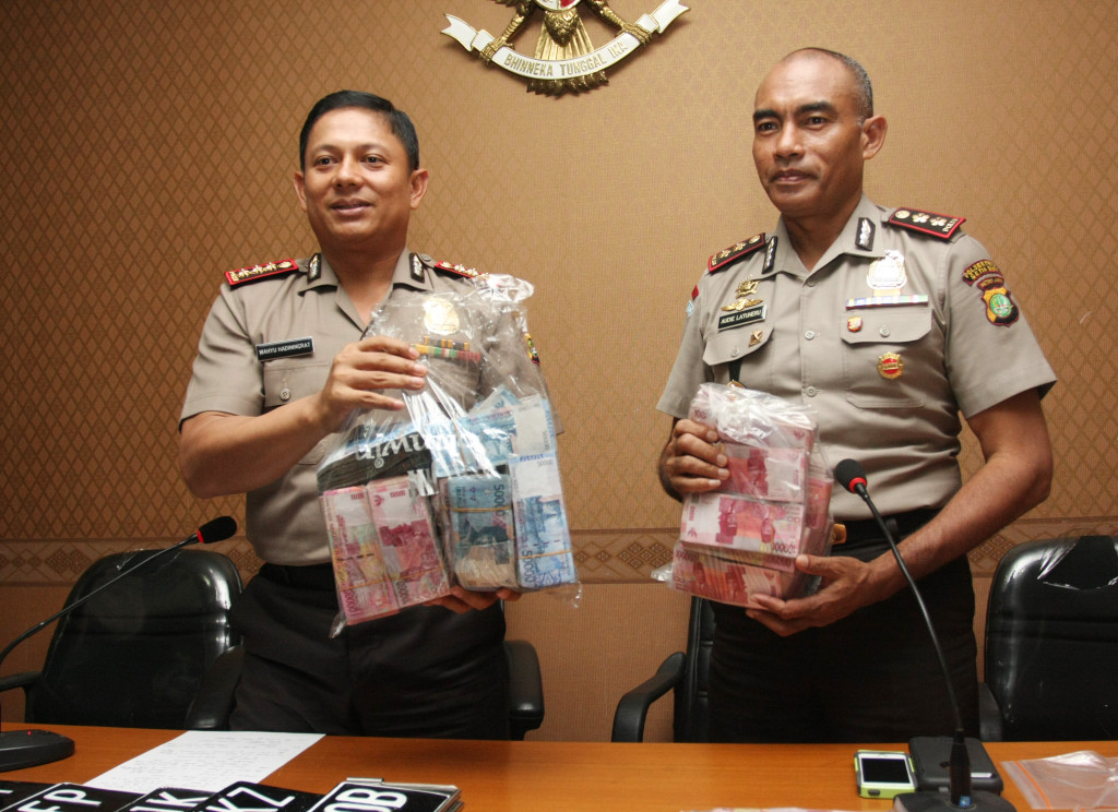 Audie S. Latuheru (kanan) menunjukan barang bukti kasus penipuan dengan modus hipnotis di Mapolres Jakarta Selatan, Jumat (12/12/2014). Antara Foto/Reno Esnir