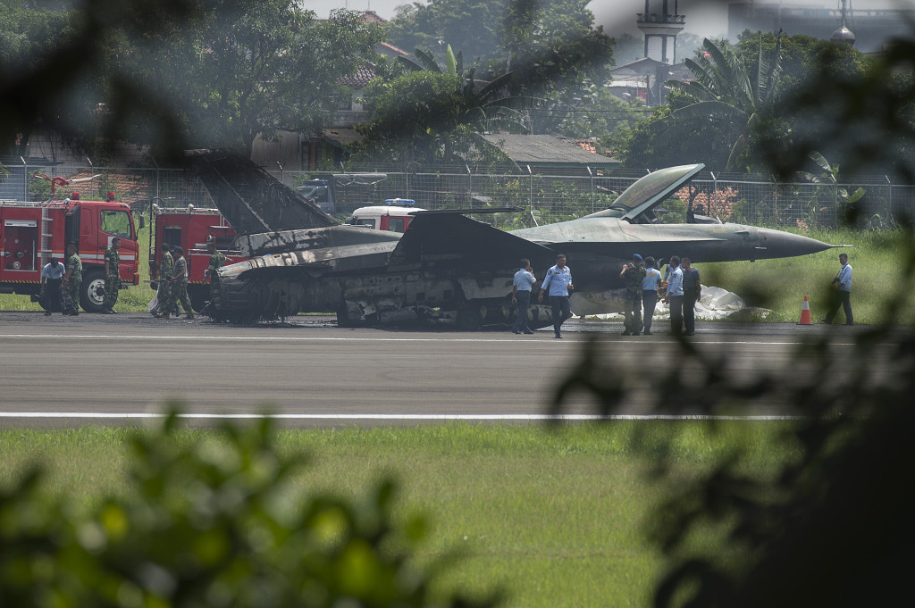 Prajurit TNI AU menjaga pesawat tempur F-16 yang terbakar di ujung landasan pacu Pangkalan Udara Halim Perdanakusuma, Jakarta Timur, Kamis (16/4). Antara Foto/Widodo S. Jusuf