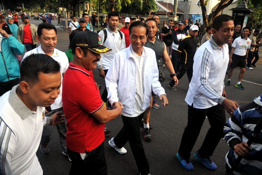 Presiden Jokowi didampingi Walikota Surakarta FX Hadi Rudyatmo melakukan kegiatan jalan sehat sembari menyapa warga kota di ajang Solo Car Free Day, Minggu (24/5/2015). Foto; MI/Widjajadi