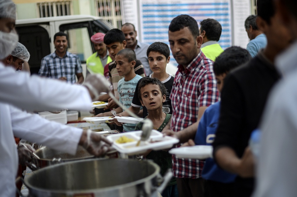 Warga Suriah berbuka puasa bersama di Akcakale, provinsi Sanliurfa, 20 Juni 2015. AFP / BULENT KILIC