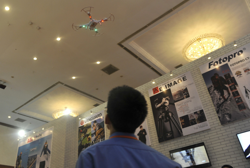 Seorang pria mengoperasikan drone yang memiliki kemampuan fotografi dan video pada pameran fotografi di JCC, Jakarta, Rabu 4 Maret 2015. Antara Foto/Andika Wahyu