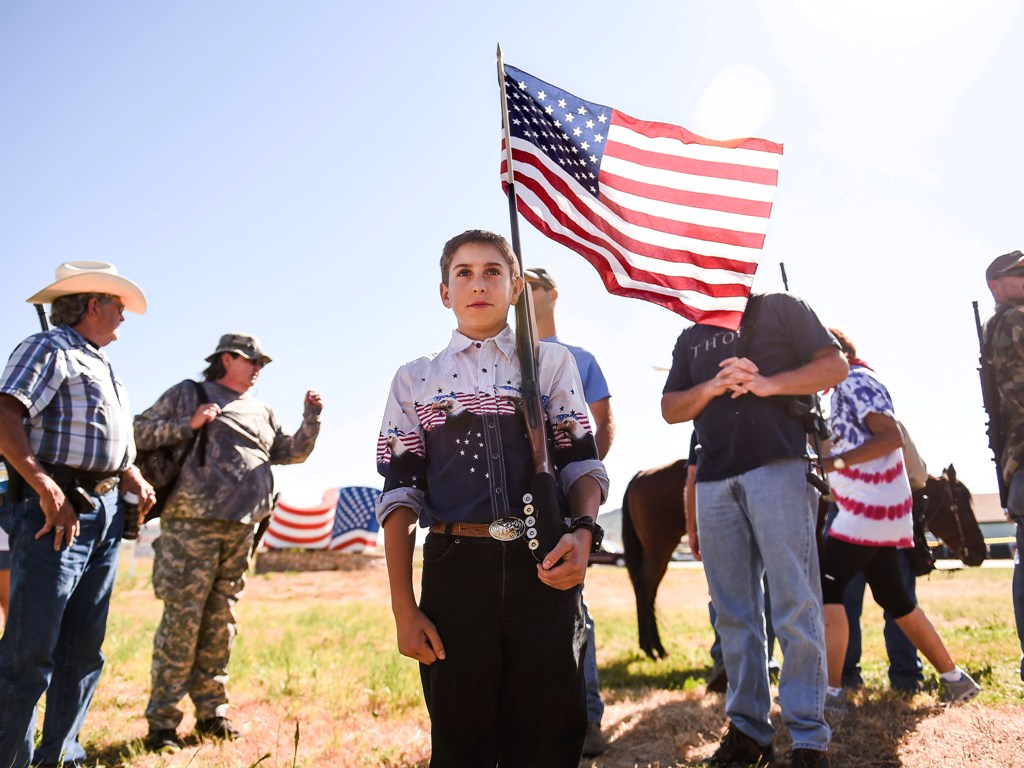J.P. Thornsley, 12, membawa bendera AS yang diikat ke senapannya pada peringatan kemerdekaan AS pada 4 Juli 2014. (Foto: AP)