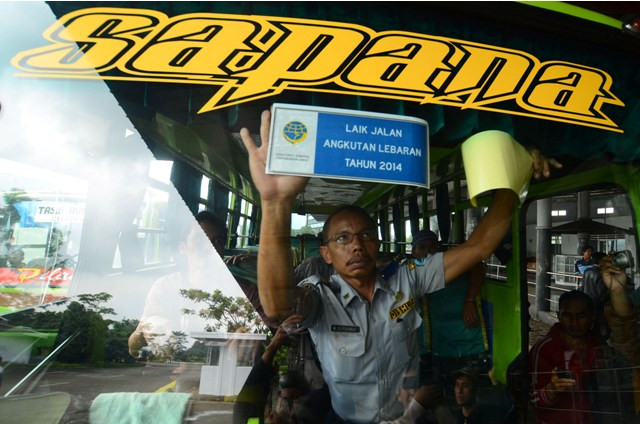 Petugas menempel stiker tanda bus layak jalan. (Foto: Antara/Adeng Bustomi)