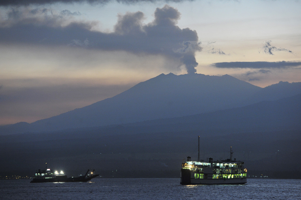  Dua Kapal Ferry yang membawa pemudik menyeberangi Selat Bali dengan latar belakang erupsi Gunung Raung pada H-5 Lebaran di Pelabuhan Gilimanuk, Jembrana, Bali, Minggu 12 Juli 2015. Antara Foto/Nyoman Budhiana