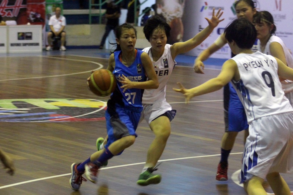 Pebasket putri China Taipei (kiri) berusaha melewati pebasket putri Korea Selatan saat bertanding di Kejuaraan Federasi Bola Basket (FIBA) Putri Asia U-16 2015, di Medan, Sumatera Utara, Rabu (5/8). (Foto: ANTARA FOTO/Septianda Perdana)
