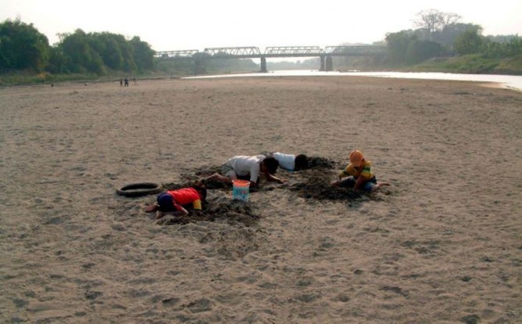 Empat remaja di Desa CampurejoKec. Kota Bojonegoro, Jatim, Rabu (8/9/2004) sedang bermain membuat galian pasir di dasar sungai Bengawan Solo yang mengering akibat kemarau. Foto: Antara/Aguk Sudarmojo