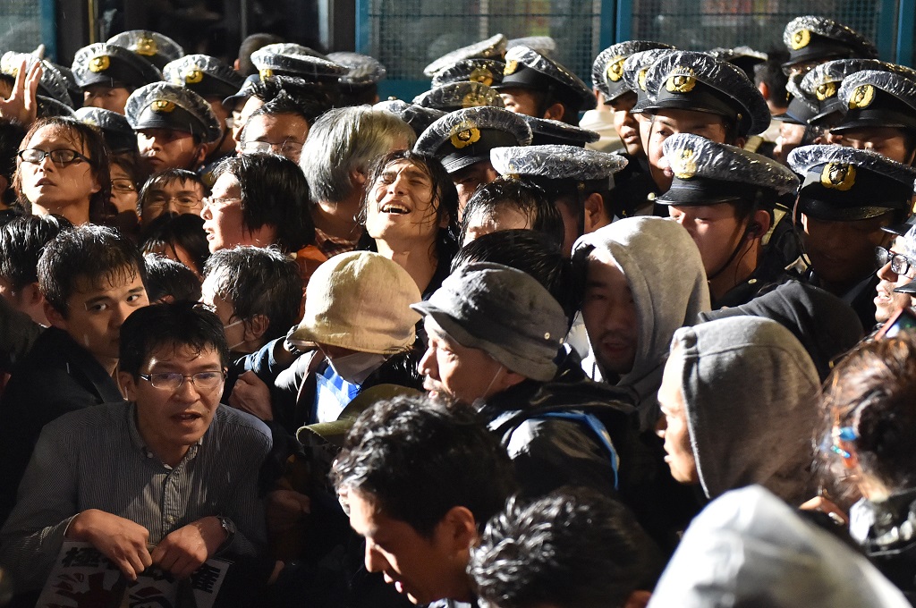 Polisi berada di tengah kerumunan pendemo di depan gedung parlemen di Tokyo, Jepang, Rabu (16/9/2015) malam. (Foto: AFP / KAZUHIRO NOGI)