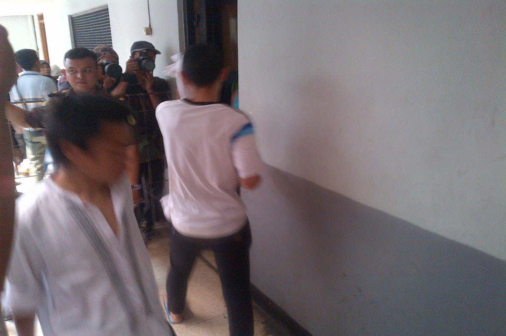 Prio, terdakwa pembunuh Deudeuh, menutup wajah saat hendak disidang----MTVN/Aulia