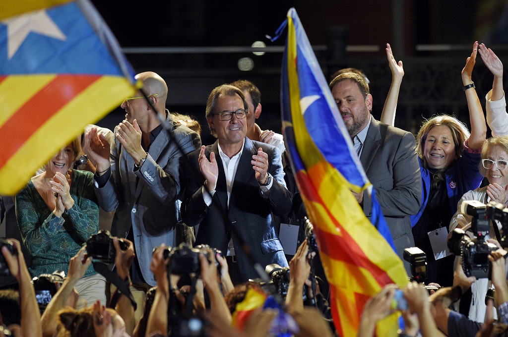 Kepala gerakan pro kemerdekaan Catalonia, Artur Mas (tengah), merayakan kemenangan bersama pendukungnya di Barcelona, Spanyol, Minggu (27/9/2015). (Foto: AFP / LLUIS GENE)