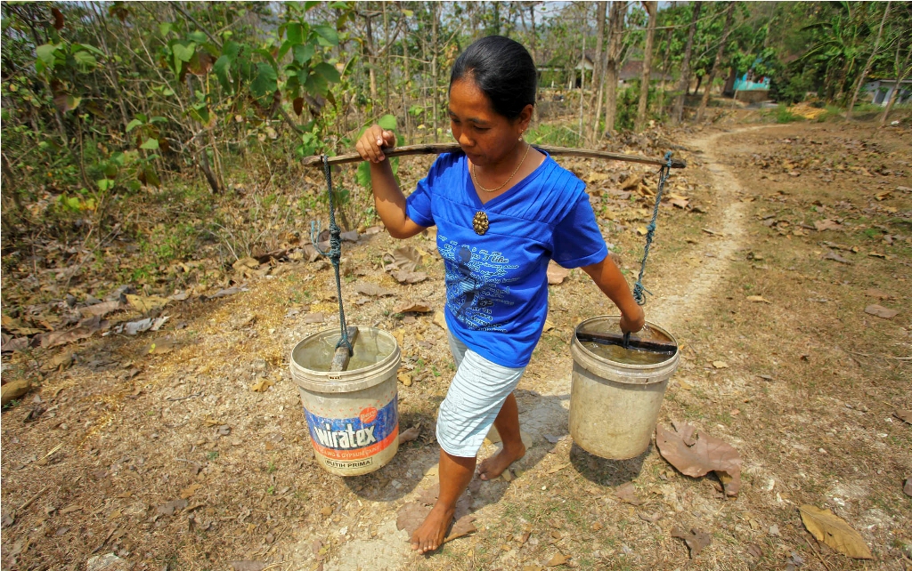 Warga membawa air bersih sumbangan PMI Sleman dan Rotary Club of Yogyakarta Taman Sari di Gayamharjo, Prambanan, Sleman, Yogyakarta, Jumat (7/8). Foto: Antara/Andreas Fitri Atmoko