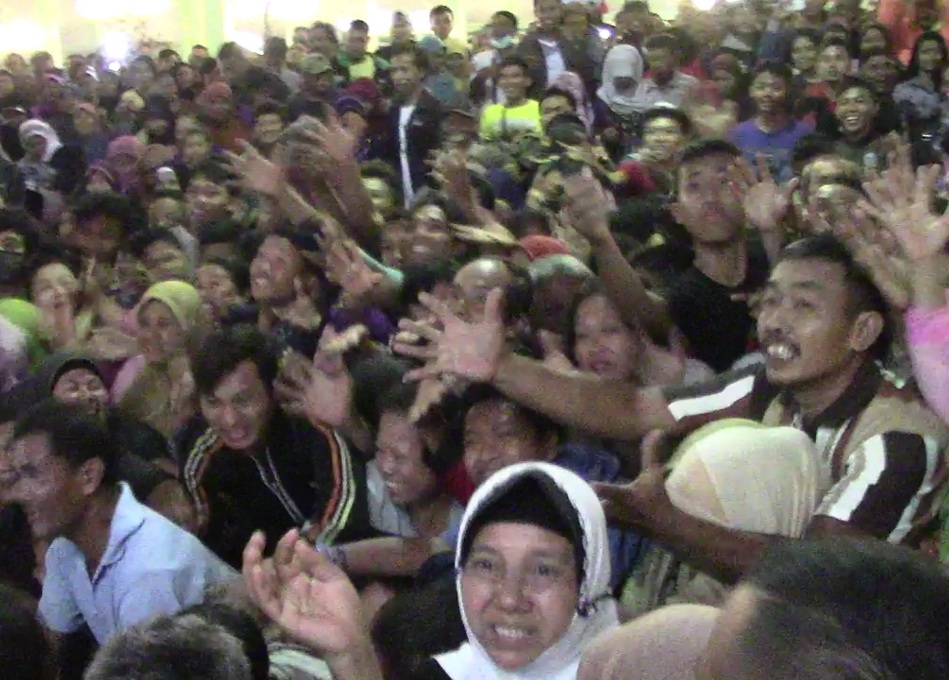 Usai merebutkan air sisa jamasan pusaka, warga berebut uang koin dalam prosesi udik-udik di Pura Mangkunegaran, Solo, Jawa Tengah. (Metrotvnews.com/Pythag Kurniati)