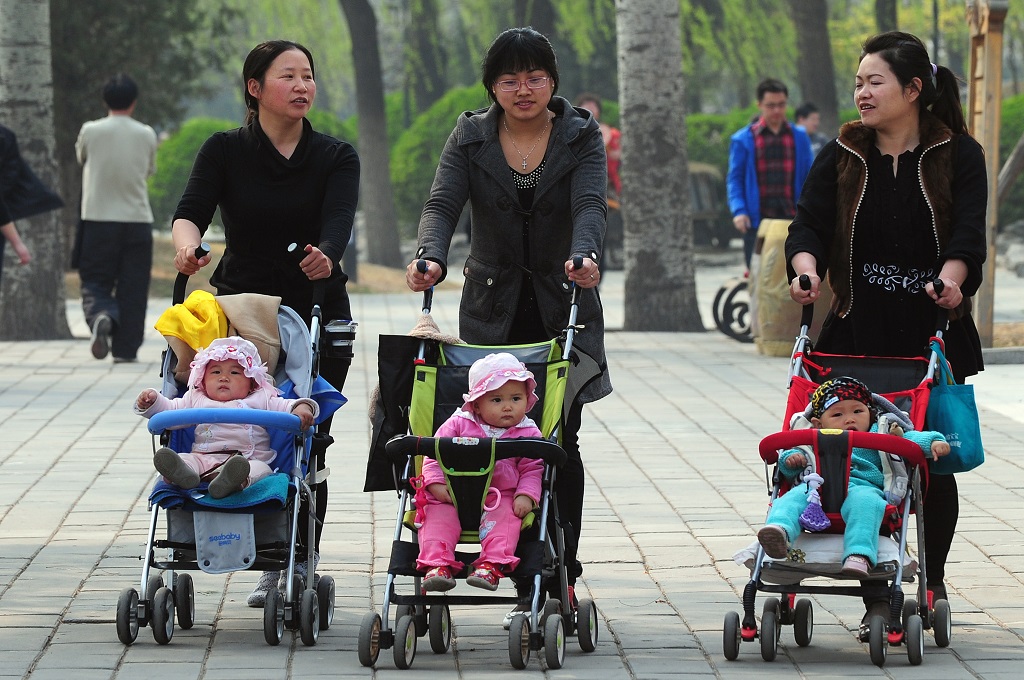 Tiga ibu mengasuh anaknya di sebuah taman di Beijing, Tiongkok, 5 April 2011. (Foto: AFP / FREDERIC J. BROWN)