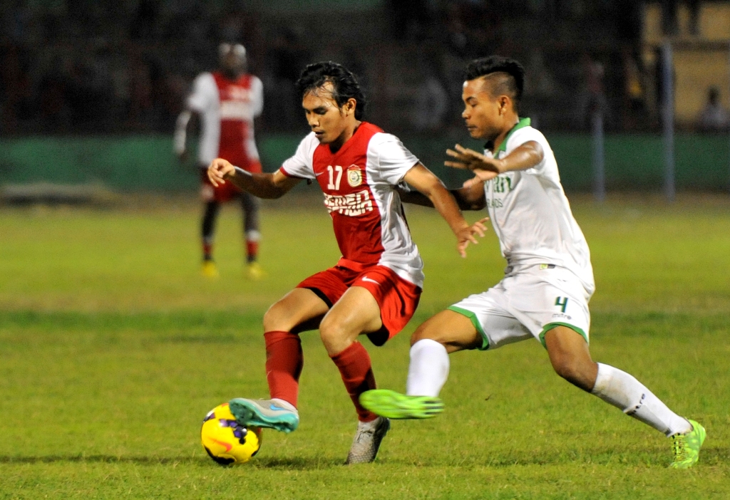Pesepak bola PSM Makassar Rasyid Bakri (kiri) berusaha melewati pesepak bola Surabaya United Asep Berlian (kanan) saat laga persahabatan. (ANTARA FOTO/Yusran Uccang)