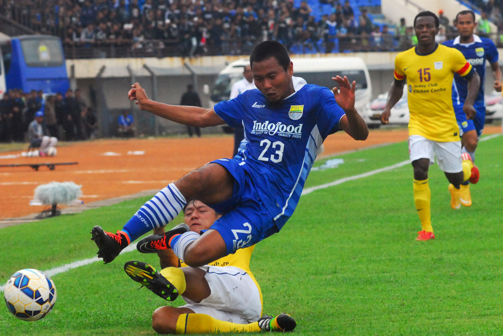 Pesepak bola Persib Bandung M. Ridwan (atas) berebut bola dengan pesepak bola Kitchee SC Cheung Kin Fung (bawah). (ANTARA FOTO/Agus Bebeng)