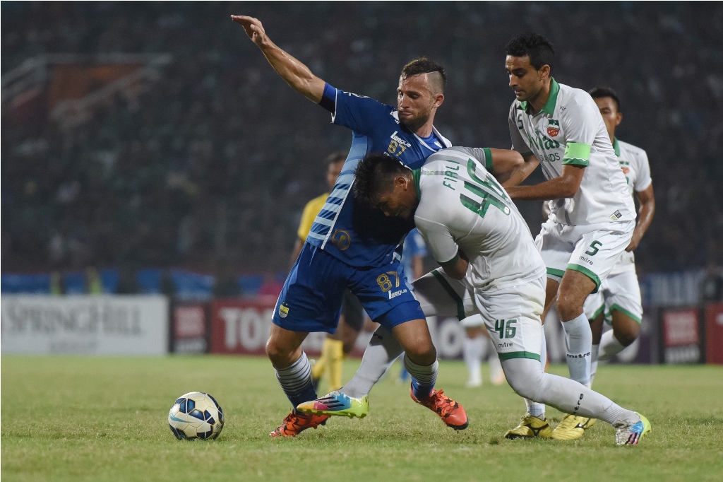 Striker Persib Bandung Iliya Spasojevic (biru) berebut bola dengan pemmain Surabaya United Firli Apriansyah (putih) pada pertandingan Piala Jenderal Sudirman di Stadion Gelora Delta Sidoarjo, Sidorajo, Jawa Timur, Sabtu (21/11). (Foto: ANTARA/ZABUR KARURU