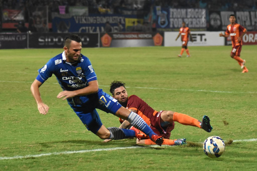 Bek PBFC Diego Michiels melakukan tekel kepada striker Persib Ilija Spasojevic pada laga penyisihan Grup C Piala Jenderal Sudirman. Kalah 0-2, Persib dipastikan gagal lolos ke perempat final (Foto:  ANTARA FOTO/M Risyal Hidayat)