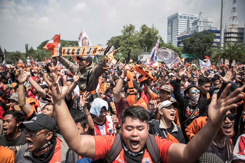 Suporter Persija Jakarta (The Jak) menyanyikan yel-yel saat long march menuju dari Jalan Medan Merdeka Selatan menuju Istana Negara.  (MI/ATET DWI PRAMADIA)