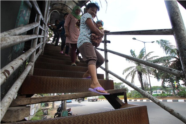Pejalan kaki harus ekstra hati-hati menggunakan Jembatan Penyebrangan Orang (JPO) yang rusak. (Foto: Antara/Rivan Awal)