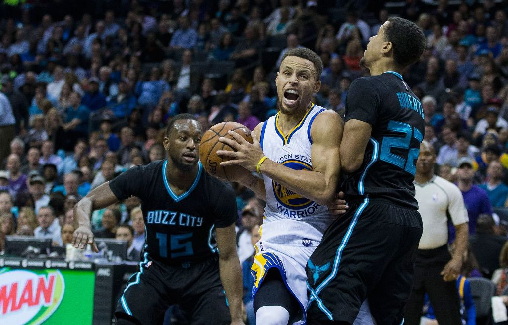 Stephen Curry (Tengah) melewati hadangan pemain Hornets. (Foto: AFP/Brian A. Westerholt)