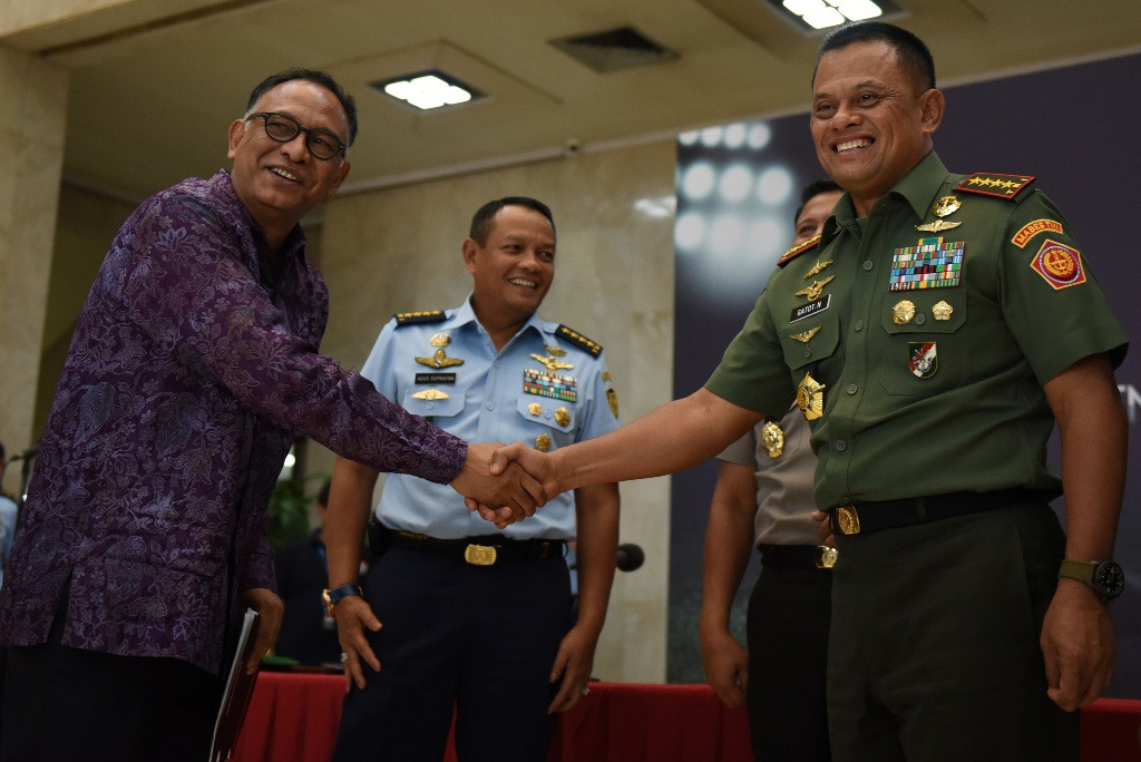 Panglima TNI Jenderal Gatot Nurmantyo (kanan) berjabat tangan dengan CEO Mahaka Sport Hasani Abdulgani (kiri) disaksikan Kasau Marsekal TNI Agus Supriatna (tengah) seusai melakukan konferensi pers penyelenggaraan Jenderal Sudirman Cup. (ANTARA FOTO/Hafidz