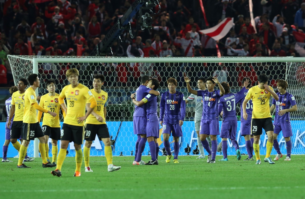 Emosi berbeda dialami dua kesebelasan, para pemain Sanfrecce Hiroshima (ungu) merayakan kemenangan usai menang atas Guangzhou Evergrande (Foto: AP Photo/Eugene Hoshiko)
