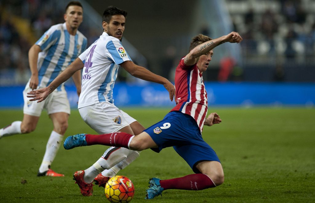 Gelandang Malaga Jose Luis Garcia Recio (Kiri) mengadang pergerakan striker Atletico Madrid Fernando Torres (Kanan) (Foto: AFP/Jorge Guerrero)