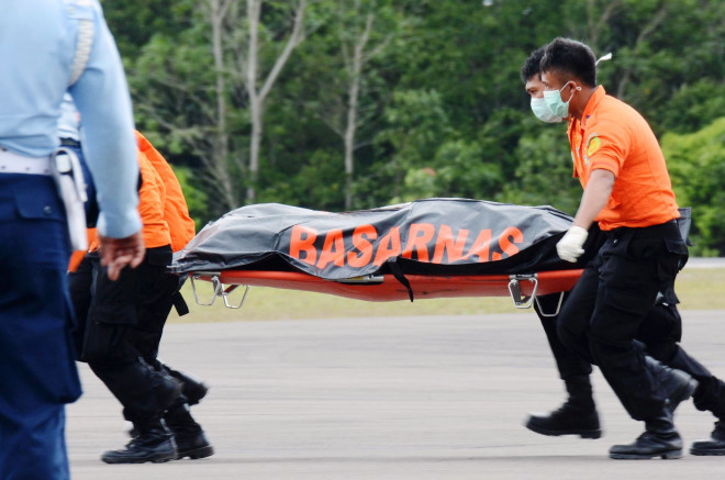 Tim SAR mengusung tandu berisi jasad korban AirAsia QZ-8501 di Lanud Pangkalan Bun, Kalteng. (foto: AP/Dewi Nurcahyani)